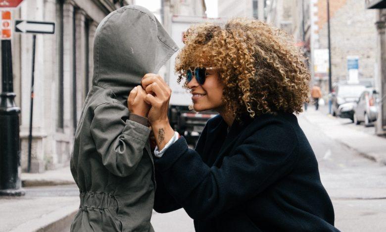 Mom pulling hoodie over child's head