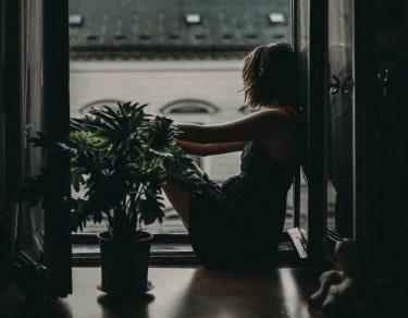 woman sitting on floor looking out