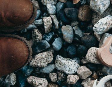 top view of child's shoe and toy on pebbles