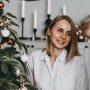 mother and toddler daughter sitting in front of christmas tree