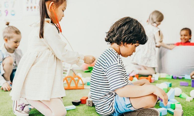young girl pretends to examine young boy