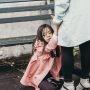 mother holds daughters hands while daughter sits on floor