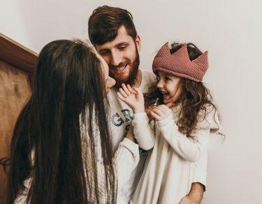 mom and dad playing with daughter wearing crochet crown