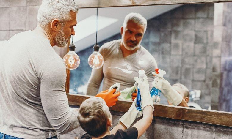Father and son cleaning mirror
