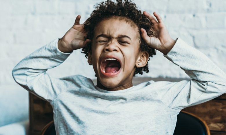 boy upset and crying in chair