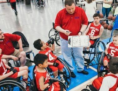 coach talking to special needs basket ball team