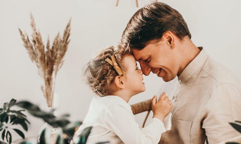dad looks into daughter's eyes while both smile
