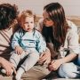 parents sitting on floor while looking at toddler