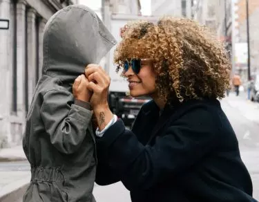 Mom pulling hoodie over child's head