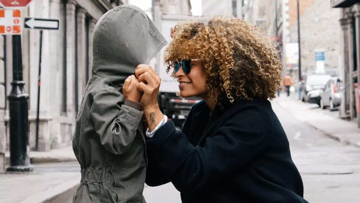 Mom pulling hoodie over child's head