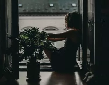 woman sitting on floor looking out