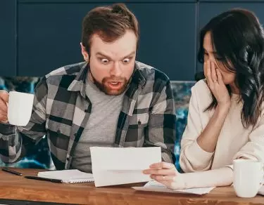 surprised man looking at paper woman shows him