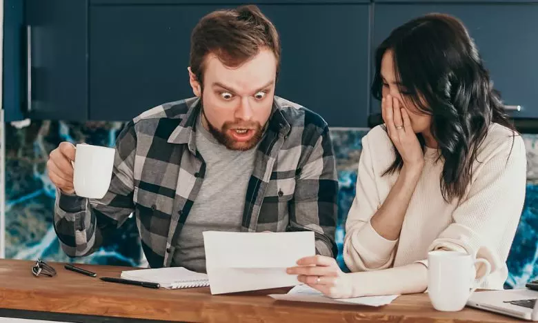 surprised man looking at paper woman shows him