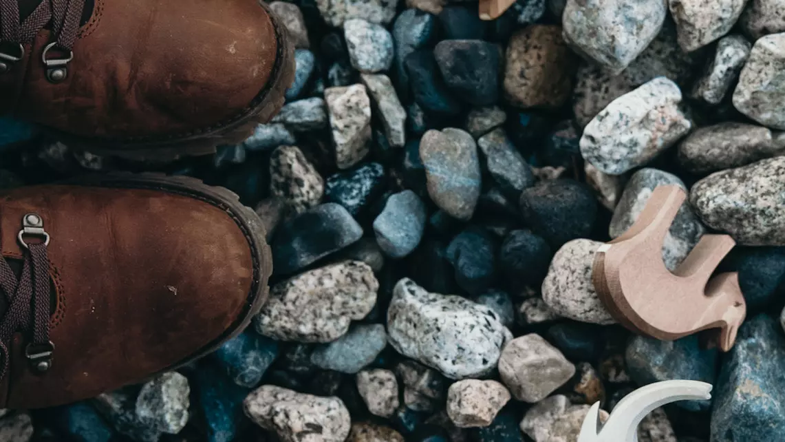 top view of child's shoe and toy on pebbles