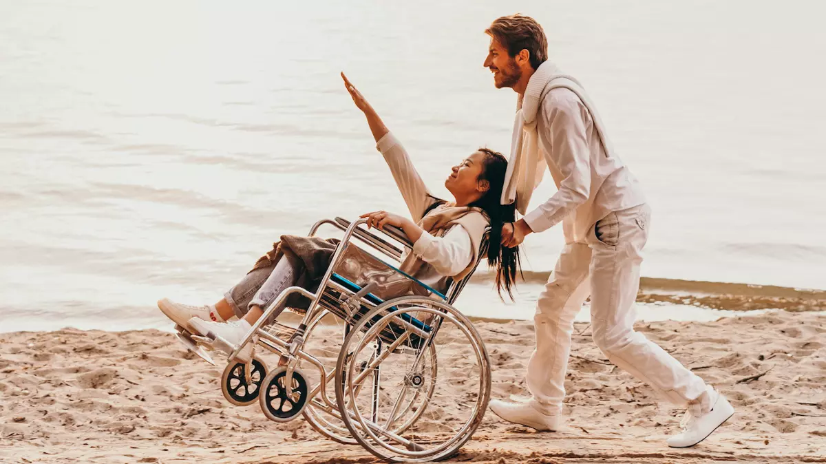 man pushing woman in wheelchair on beach