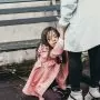 mother holds daughters hands while daughter sits on floor