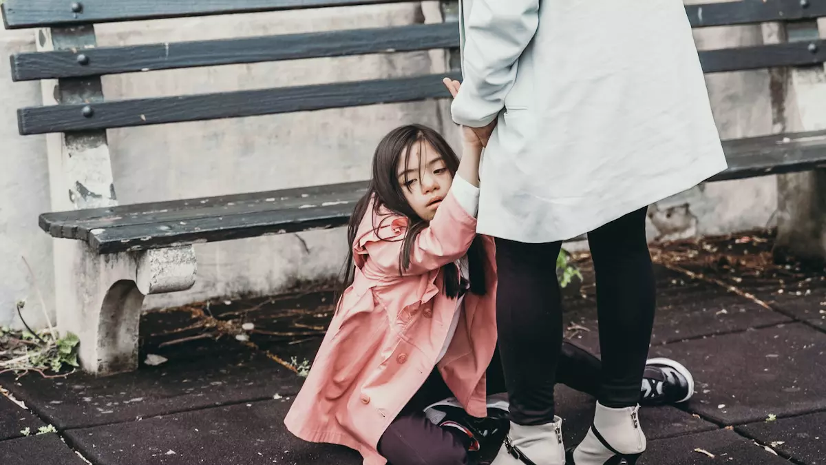 mother holds daughters hands while daughter sits on floor