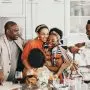 family gathered in kitchen while two women hug