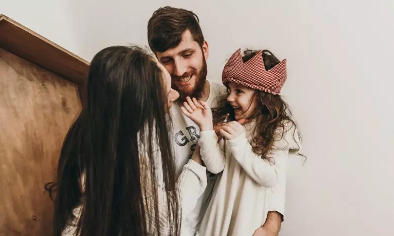 mom and dad playing with daughter wearing crochet crown