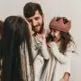 mom and dad playing with daughter wearing crochet crown