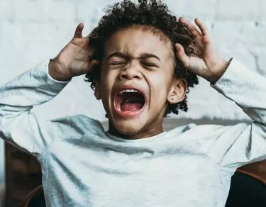 boy upset and crying in chair